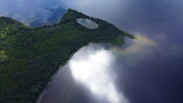High-Altitude Drone View of a Forested Peninsula with a Small Oval Lake on the Shore of Lake Matapedia, Quebec, Canada