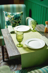 Stylish Green-Themed Restaurant Table Setting with Elegant Glassware and Cozy Ambiance