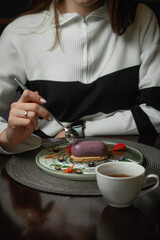 Elegant Woman Enjoying a Gourmet Blueberry Mousse Dessert with Tea