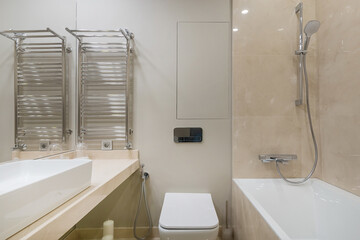 The interior of a small bathroom in pastel colors. Bath with shower, Mirror over the .sink.