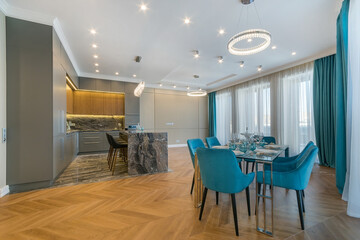 Exclusive interior design of the kitchen and dining room. Parquet floor, panoramic Windows. Stylish furniture, elegant table setting.