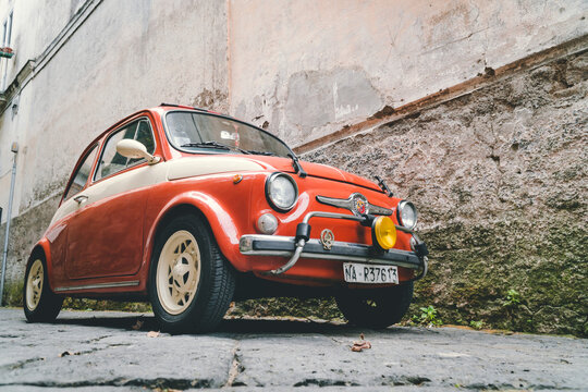 Meta, Sorrento, Italy - 25 October 2017:An old Fiat 500 racing style, orange and white body color. yellow fog light. small Italian street.