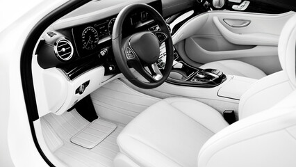 A white car with a black steering wheel and a white seat