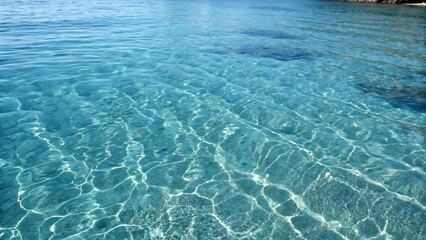 Fototapeta premium Crystal-clear blue water with sunlit ripples forming mesmerizing reflections. A tranquil aquatic background perfect for summer, relaxation, and peaceful scenery