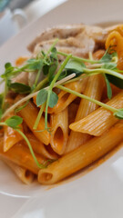 Pasta in tomato sauce with green herbs