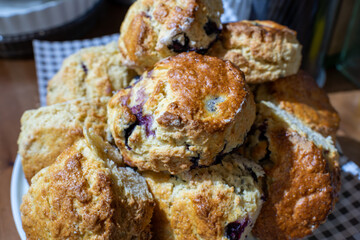 A stack of blueberry scones on a white cake stand. The scones are golden brown and look delicious