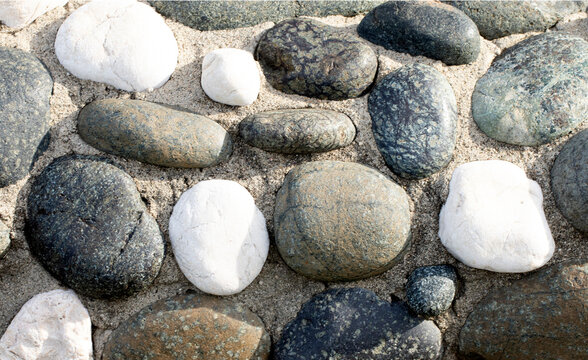 A Mediterranean-style pebble stone wall texture, with its warm, earthy tones and rugged surface, evokes a sense of timeless elegance and rustic charm, perfect for adding character to any border