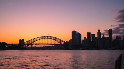 Fototapeta premium Sydney skyline during sunset, with warm colors reflecting off the water
