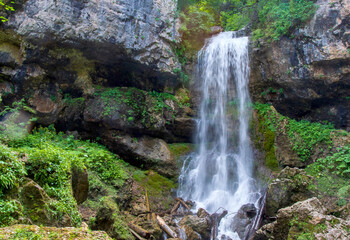 a waterfall, a fragment of a mountain river in the embrace of a stone canyon and a deep riverbed, a spring day in nature