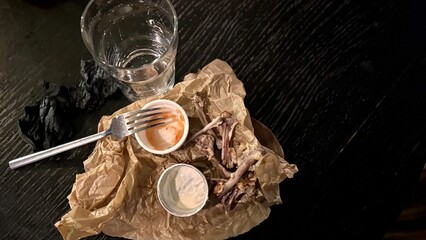An Empty Dining Plate that has Leftover Food and Beverages Resting on a Table Surface