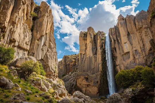 Stunning natural landscape featuring towering rock formations and cascading waterfalls in a serene setting during daylight hours