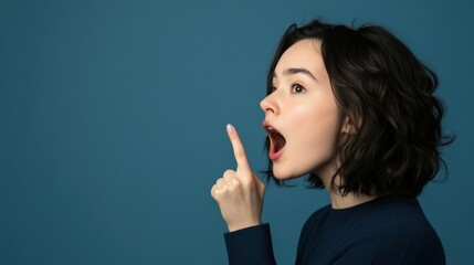 Obraz premium Surprised Woman Pointing Upwards Against Blue Background