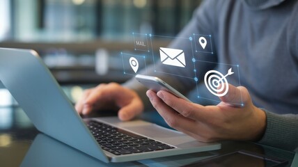 Person using laptop and smartphone with overlaid digital icons