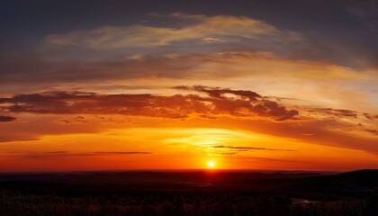 Fototapeta premium wide panorama of a glowing orange striped sunset sky