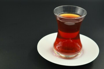 A glass of Turkish tea on izolated black background