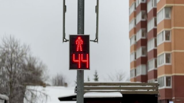 Red light at the old traffic light for pedestrians in the form of a stopwatch and a man in winter. Close-up
