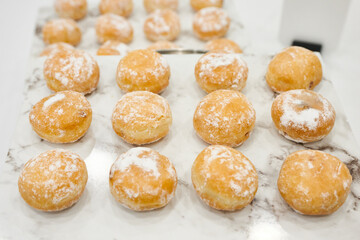 Cream filled buns on a wooden board ready to eat