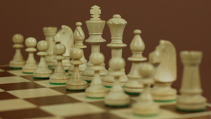 White chess pieces on a board before a game. Side view