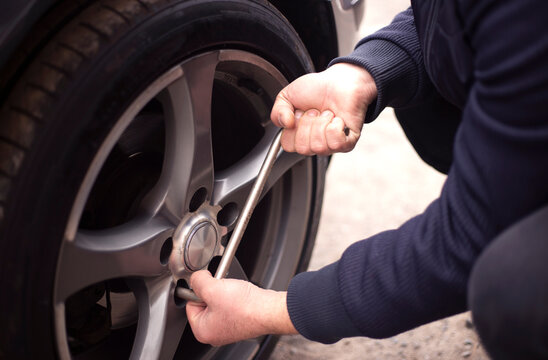 Auto mechanic changing the wheel of a car