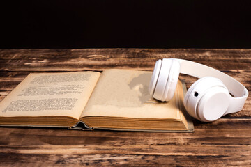 headphones book and coffee on black background