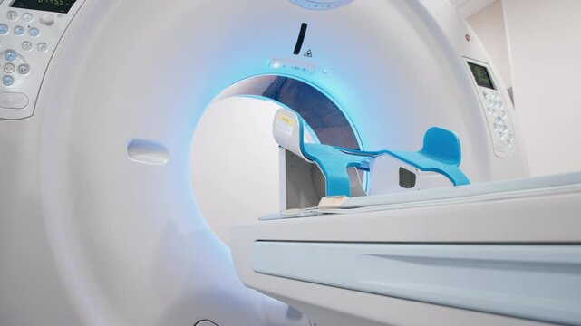 A close-up of a modern CT scanner or MRI machine in a hospital radiology center in blue pleasant lighting. Diagnostic equipment in a medical laboratory.