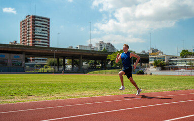 Obraz premium A man runs on a track with a blue shirt and black shorts