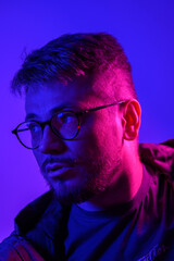 Obraz premium A stylish photo of a young man with blue-pink lighting