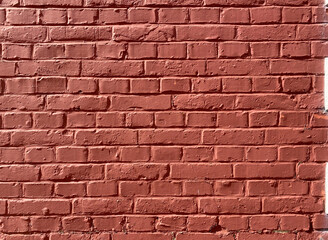 Obraz premium The image is a close-up of a brick wall. The bricks are arranged in a horizontal pattern, with each brick slightly overlapping the one below it. The color of the bricks is a deep, rich red.