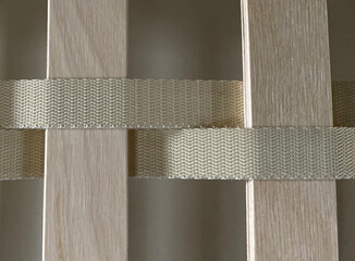 The image shows a close-up of a wooden lattice structure. The lattice is made up of horizontal...