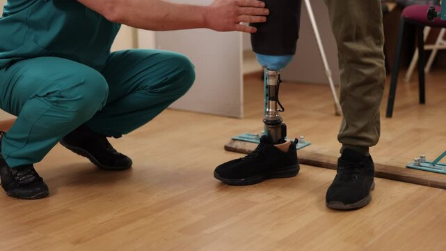 mobility recovery, therapist patient, recovery training. Physical therapist helps patient regain mobility by guiding them through walking exercises with parallel bars.