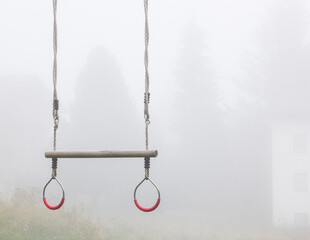 Kids swingset in the fog of a small European town