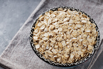 Raw Organic Rolled Oats in Bowl on Linen Napkin, Copy Space