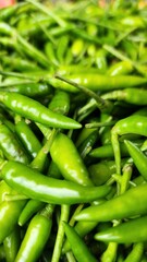 Green, Red and yellow hot chili peppers on display at a market stall.