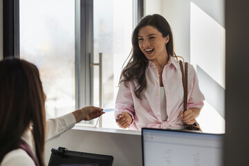 Young woman interacts with receptionist at a modern office