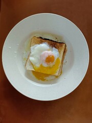 fried egg on top of a toast bread in a plate