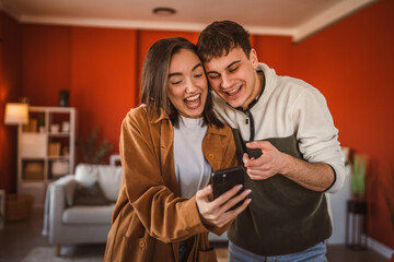 youth couple boyfriend and girlfriend use mobile phone for fun at home