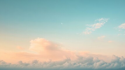 Obraz premium A serene sky at dusk, featuring soft pastel clouds illuminated by warm hues, with a crescent moon visible in the clear blue expanse.