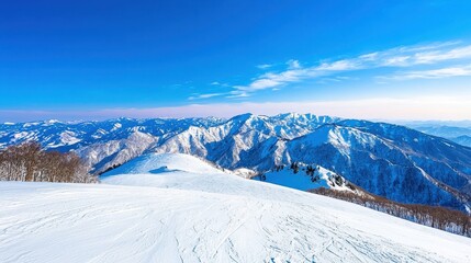 Obraz premium Snowy mountain range stretches beneath a clear bright blue sky