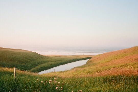 Sunrise over peaceful waters and grassy hills at a serene coastal location