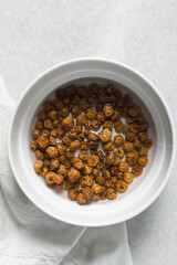 Overhead view of dried tiger nuts in a white bowl. top view of Yellow Nutsedge in a bowl