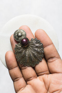 Overhead view of pewter earrings on marble jewelry holder, top view of vintage pewter earrings on a white background