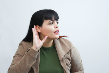 Curious woman listening attentively, hand near ear, expressing curiosity and surprise. Perfect for...