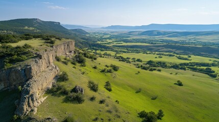 Obraz premium A Vast Landscape View Of A Rugged Cliff And Green Grasslands