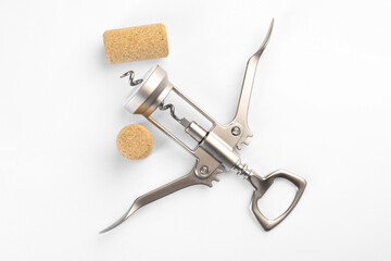 Wing corkscrew and corks on white background, top view