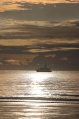 Ship At Sea On Golden Sunset Coastline