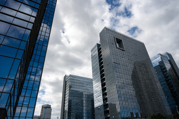 Obraz premium Modern Skyscrapers Reflecting Cloudy Sky
