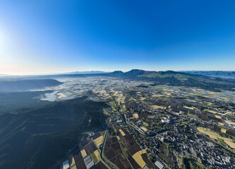 阿蘇市、農地、農業、阿蘇山、風景、景色、パノラマ、絶景、空撮、ドローン、山麓、都市、街、社会、田畑、農家、道路、インフラ、暮らし、観光、旅行、観光地、青空、地平線、展望、大地、背景、コピースペース、住宅、不動産、環境、自然、景観、明るい、快晴、昼間、超広角、山林、森林、カルデラ、盆地、地形、地理、広告、俯瞰、ハイアングル、行政、自治体、田んぼ