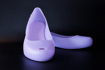 Purple flat shoes displayed against a black background, showcasing minimalist design and vibrant colors for footwear product photography. Concepts like modern fashion, comfort, woman's shoes