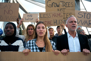 Concerned age diverse group of peaceful activists gathered at demonstration. Aware people standing...