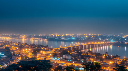 Fototapeta premium Serene Night Cityscape with Lit Bridge Over River Reflecting Lights at Dusk or Dawn Panorama